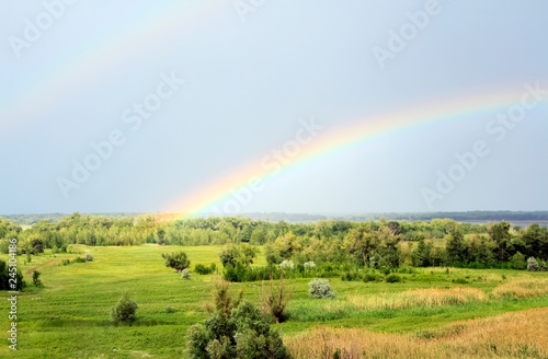 Double rainbow over the valley near the river after a rain at beautiful summer day © Aleksandr Kurganov