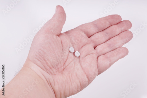 male hand holding two tablets in palm