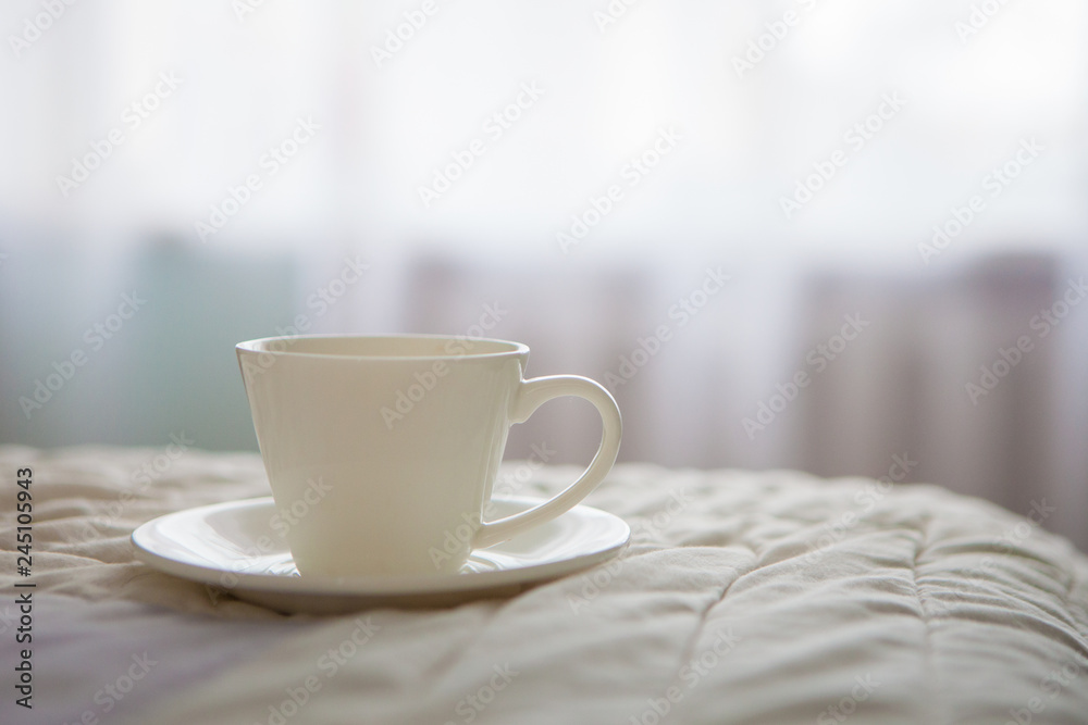 Morning cup of coffee on the background of the bed and the window Morning cup of coffee on the background of the bed and the window