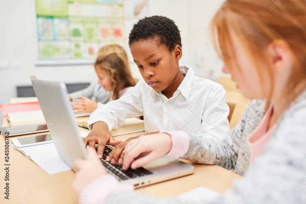 Afrikanischer Junge schreibt auf dem Laptop Afrikanischer Junge schreibt auf dem Laptop