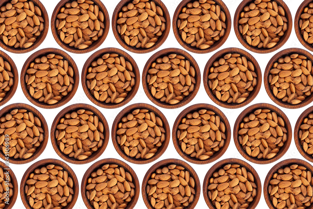 Peeled almond in a wooden cedar plate on a white isolated background. Row of bowls with almond nuts, top view. Peeled almond pattern Peeled almond in a wooden cedar plate on a white isolated background. Row of bowls with almond nuts, top view. Peeled almond pattern