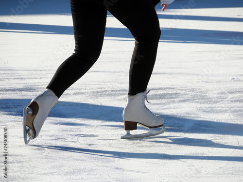 Ice skating, girl in the skates. Female legs at the rink, woman skater, winter sports and fun