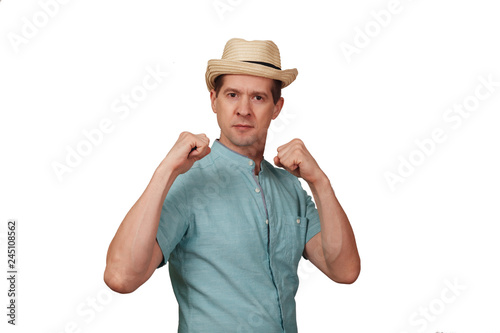 The man in a shirt and a hat keeps hands in a boxing rack
