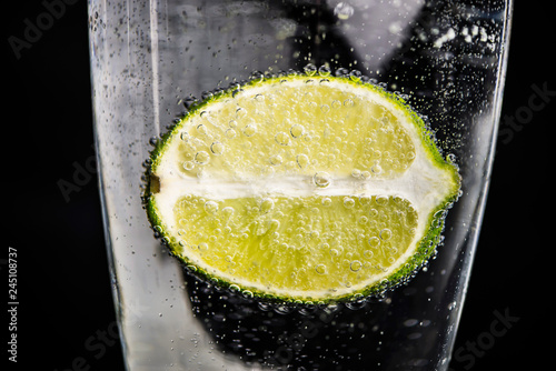 lime in a glass with water with bulbs, background