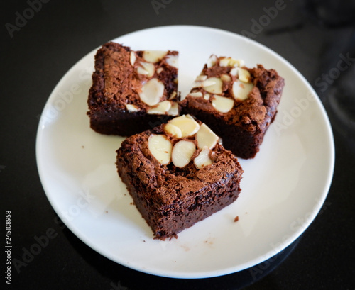 brownies cake on the table / piece of chocolate cake cocoa with nut on top view brownies slice on white plate