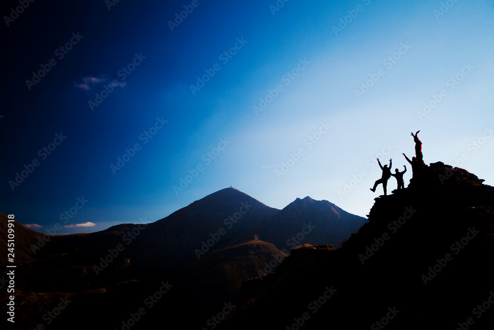 happy hikers on a rock, silhouette