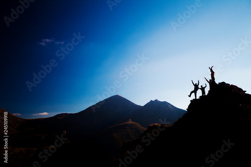 happy hikers on a rock, silhouette