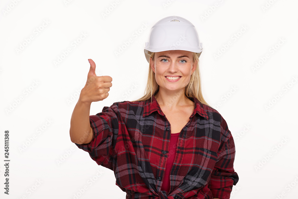 Girl in white construction helmet and red plaid shirt shows thumb up Girl in white construction helmet and red plaid shirt shows thumb up