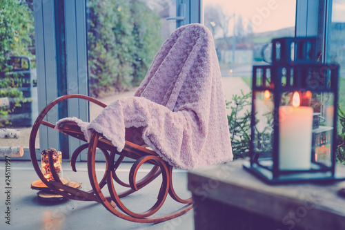 Chaise à bascule, lampion et bougie dans une ambiance cocooning à la maison. Rocking chair dans une véranda. Ambiance cocooning et reposante à la maison. photo