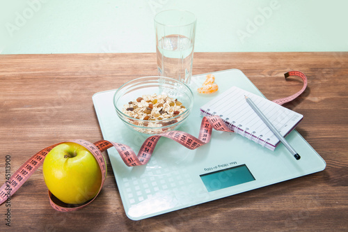 The concept of healthy diet, fitness and weight loss. Scales, measure tape on the table.