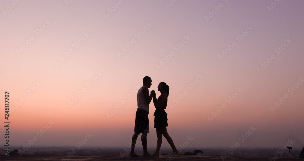 silhouette of couple felling love at sunset