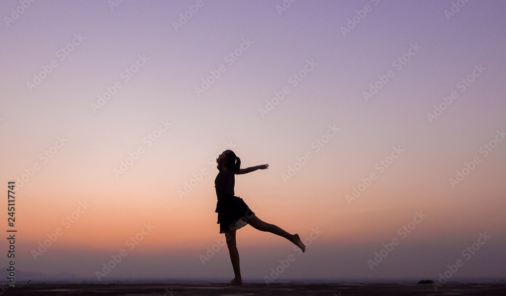 silhouette of woman dancing at sunset