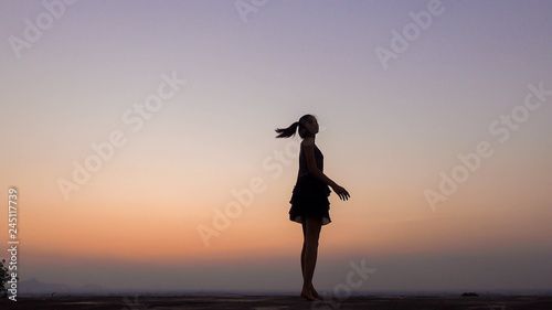 silhouette of woman blowing her hair at sunset
