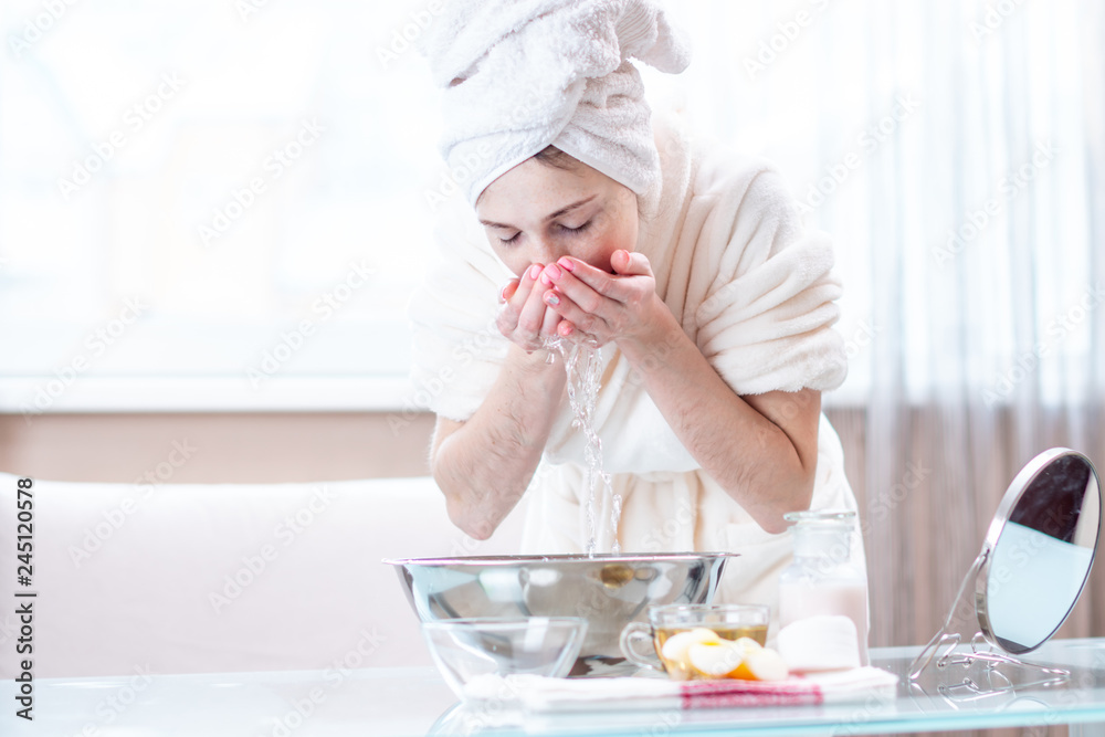 Beautiful young woman washing face with water in the morning. Concept of hygiene and care for the skin at home Beautiful young woman washing face with water in the morning. Concept of hygiene and care for the skin at home