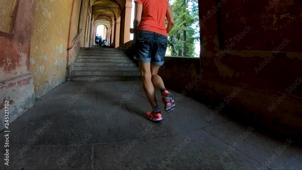 SLOW MOTION: sporty woman legs running in San Luca's portico. Longest archway in the world leading to the San Luca Sanctuary on Colle della Guardia hill. Bologna city of Italy. SLOW MOTION: sporty woman legs running in San Luca's portico. Longest archway in the world leading to the San Luca Sanctuary on Colle della Guardia hill. Bologna city of Italy.