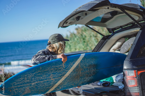 Photography surfer man with long white hair in a cap and sunglasses with a surfboard