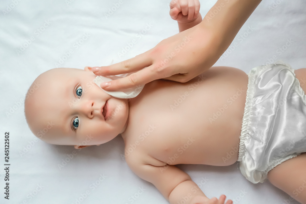 Mom cleaning up and wipe body baby by wet tissue when changing nappies or diaper and wiping the hands or face or leg, Personal hygiene for mother and Toddler kid with wet wipes paper concept Mom cleaning up and wipe body baby by wet tissue when changing nappies or diaper and wiping the hands or face or leg, Personal hygiene for mother and Toddler kid with wet wipes paper concept