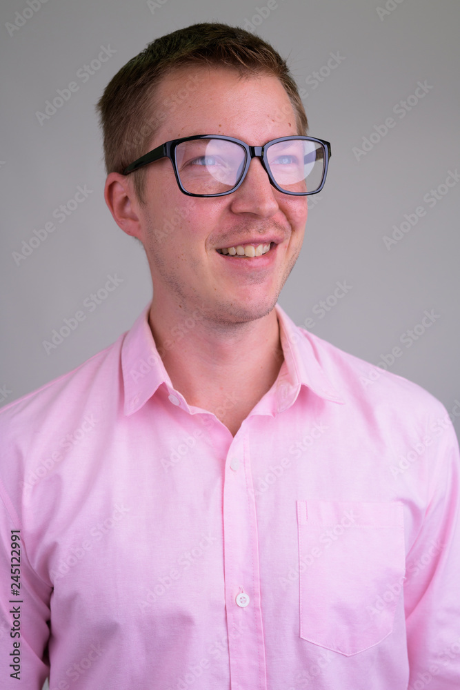 Face of young happy nerd businessman thinking with eyeglasses