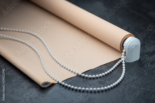 Photography The roller blind lies on a black stone surface.