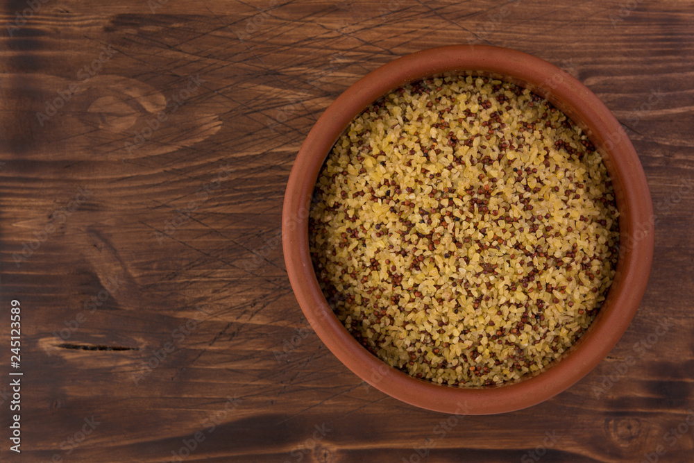 bowl of raw bulgur and quinoa on wooden table background bowl of raw bulgur and quinoa on wooden table background