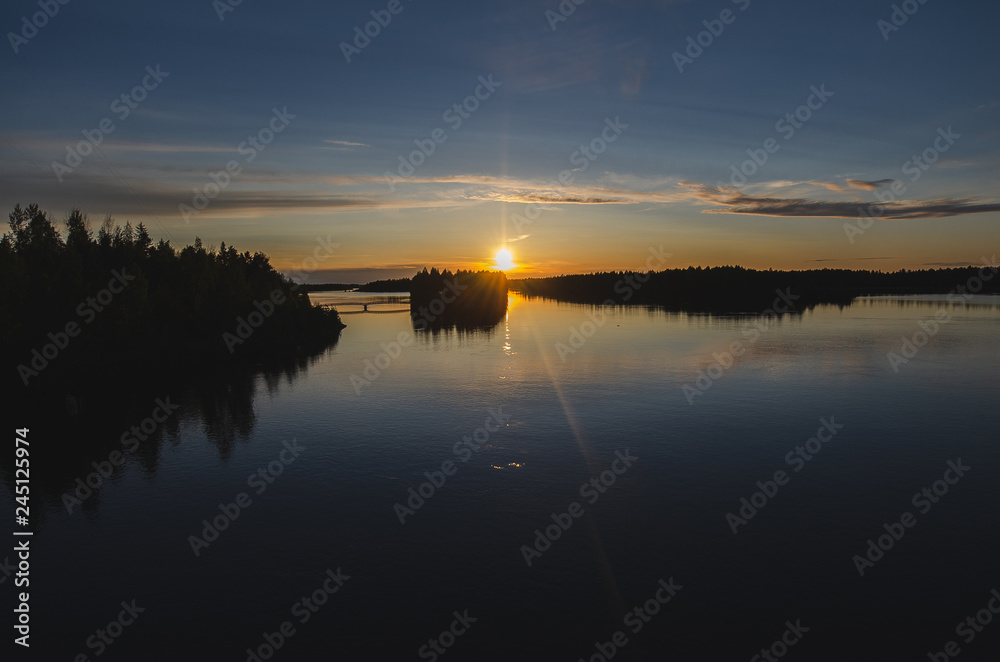Obraz premium Sunset over a lake during midsummer in Finland