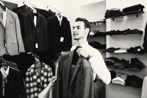 The man buyer chooses jacket the boutique