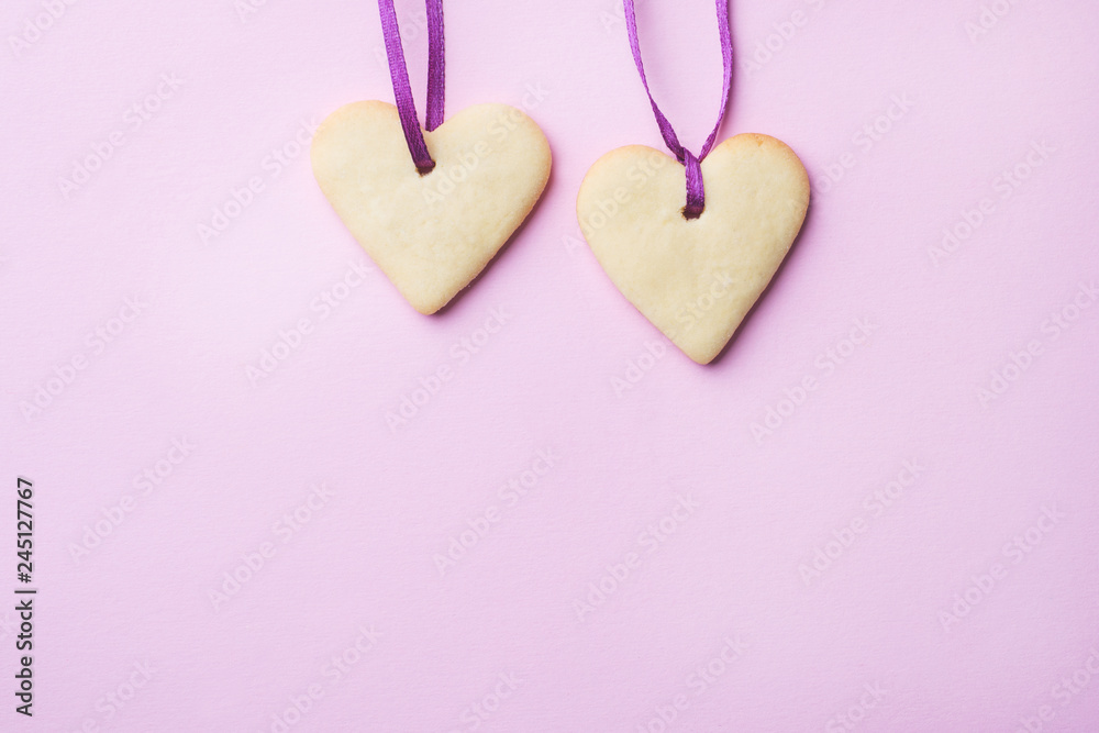 Homemade cookies in the shape of a heart on a pastel pink background. Copy space. Concept Valentine's Day