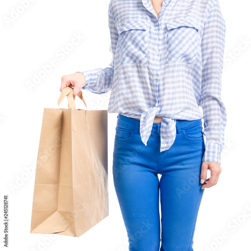 Woman in jeans and blue shirt bag package in hand fashion buy sale macro on white background isolation
