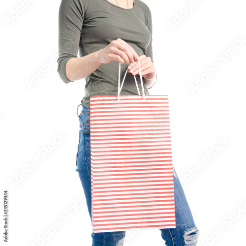 Woman in jeans and green shirt bag package in hand fashion buy sale macro on white background isolation