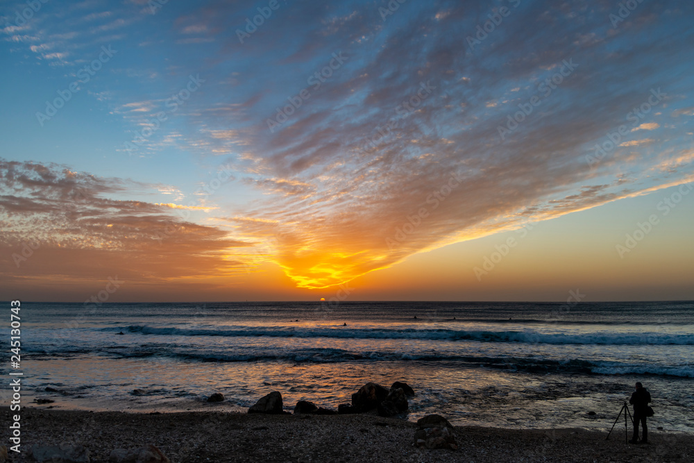 Photographer shooting the sunset on the beach