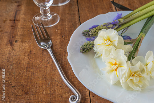 Beautiful table setting with bouquet of white daffodils and blue hyacinths