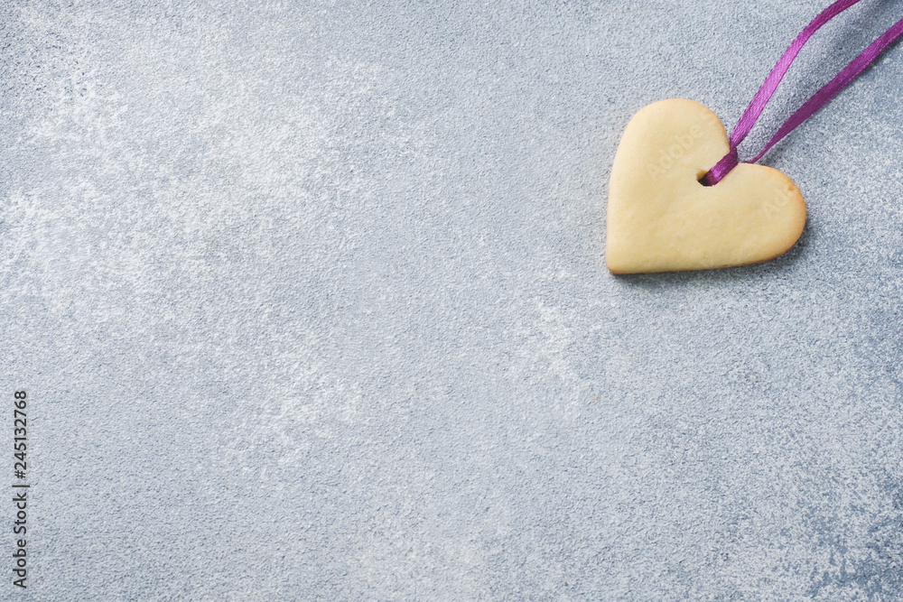 Obraz premium Homemade cookies in the shape of a heart on a grey background. Copy space. Concept Valentine's Day