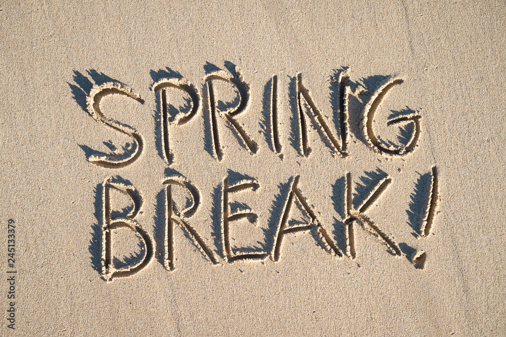 Excited Spring Break! message handwritten on the smooth sand of an empty beach with abundant sunshine Excited Spring Break! message handwritten on the smooth sand of an empty beach with abundant sunshine