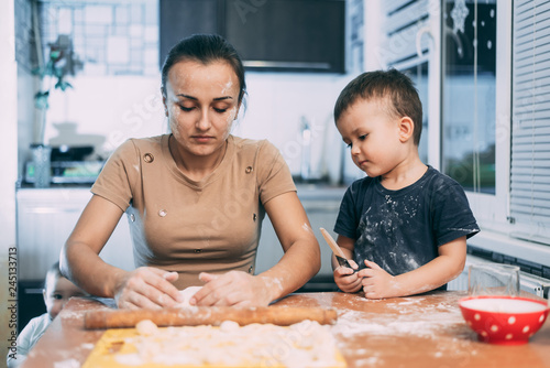mom and son cook dough and flour fun dirty in the kitchen