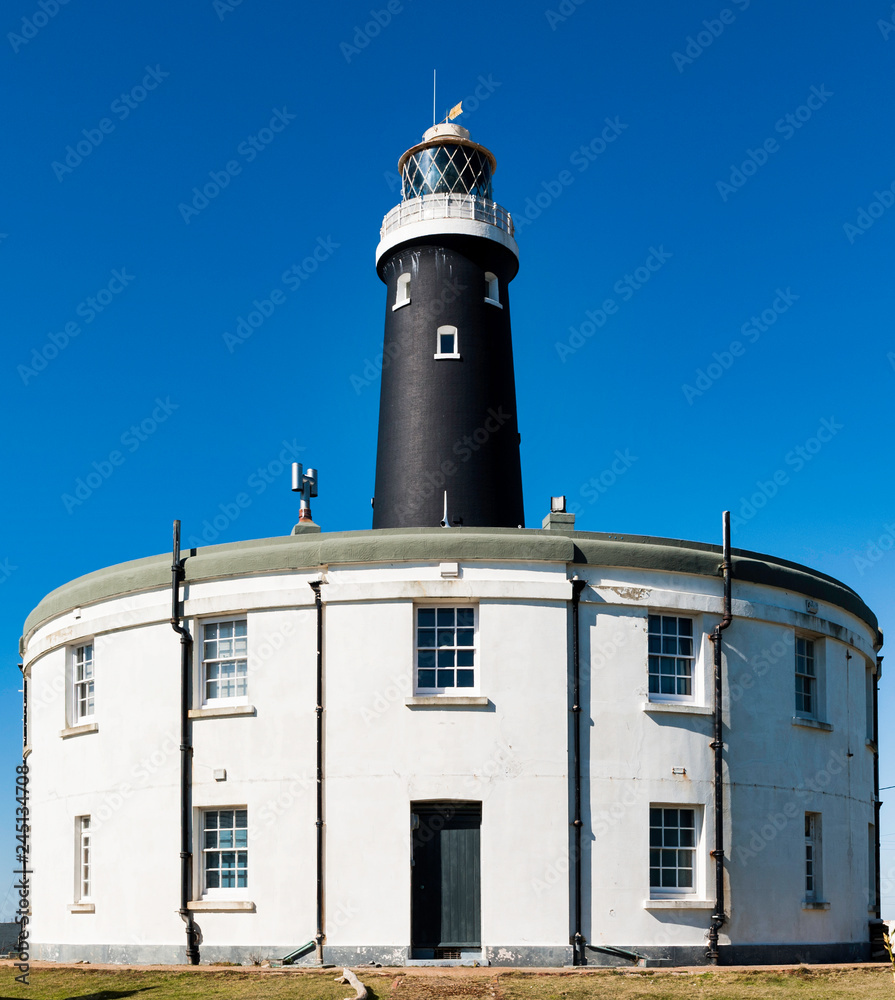 The old Lighthouse at Dungeness in Kent, England. This lighthouse is a grade 11 building and was opened in 1904. The old Lighthouse at Dungeness in Kent, England. This lighthouse is a grade 11 building and was opened in 1904.