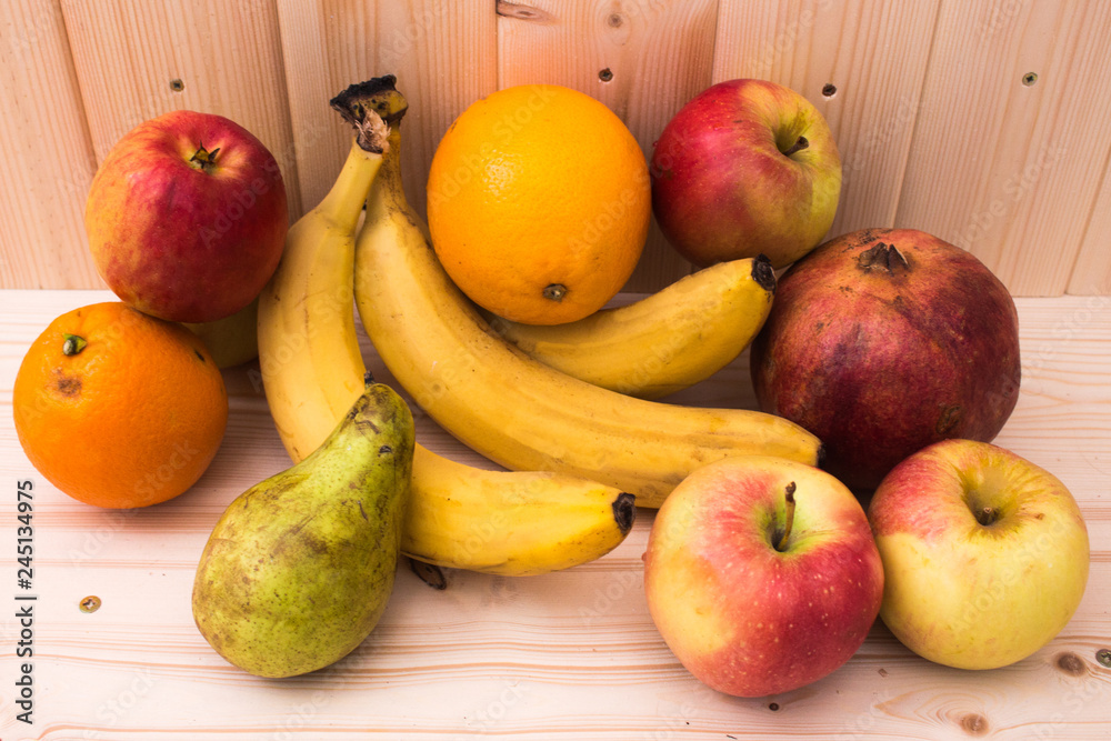 Various fruits apples, bananas, oranges, pomegranates on natural wooden background. Healthy food Various fruits apples, bananas, oranges, pomegranates on natural wooden background. Healthy food