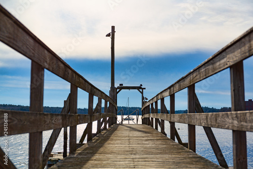 Old walkway with a sailboat in the distance photo