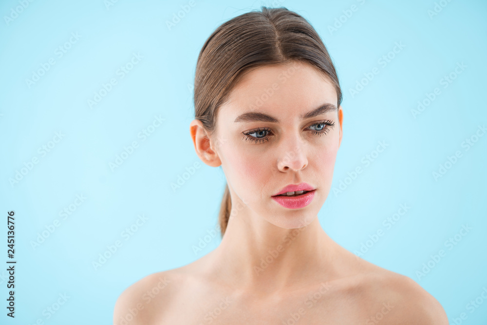 Beautiful young woman posing isolated over blue background. Beautiful young woman posing isolated over blue background.