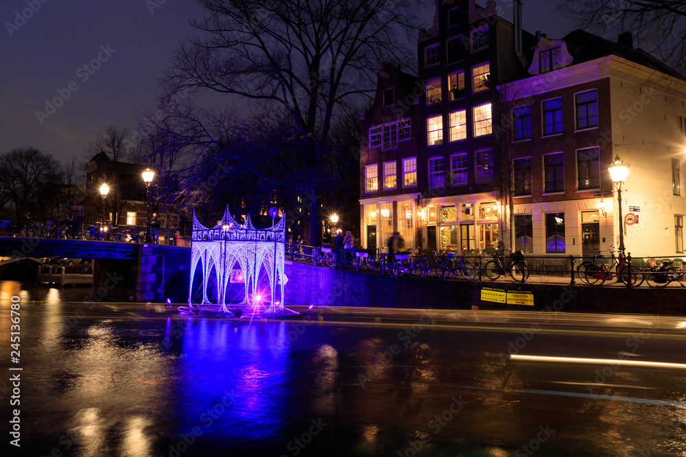 Luminous arbor on the water of the canal of Amsterdam