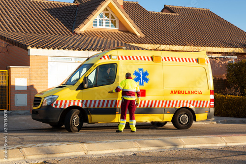 Hombre de personal sanitario entrando en ambulancia aparcada en zona residencial