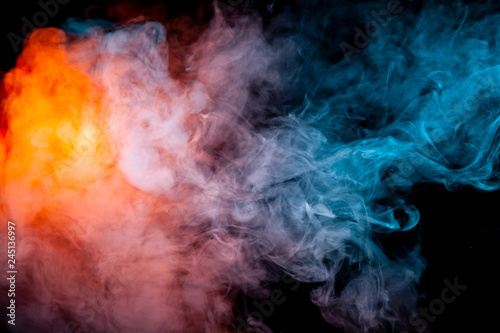 Background of orange, purple, red and blue wavy smoke on a black isolated ground. Abstract pattern of steam from vape of smoothly rising clubs.