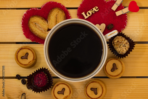 Cup of coffee and cookies on wooden background. photo