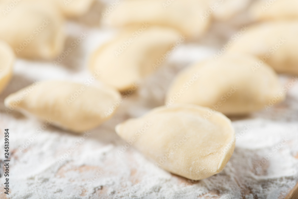 Raw dumplings ready to boil, close up. Also known as Vareniks, Ukrainian traditional cuisine Raw dumplings ready to boil, close up. Also known as Vareniks, Ukrainian traditional cuisine