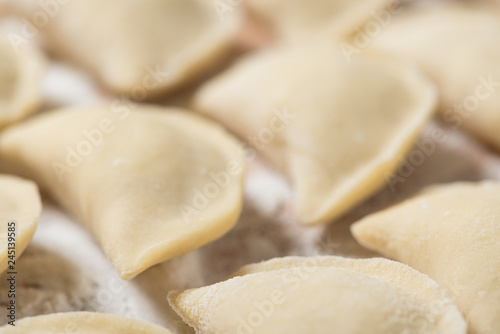 Raw dumplings ready to boil, close up, soft background with copy space. Also known as Vareniks. Ukrainian traditional cuisine