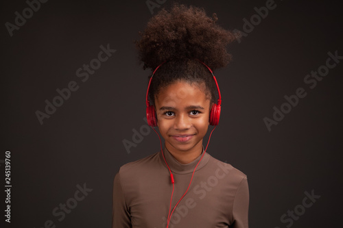 Lovely girl listening to music in red earphones
