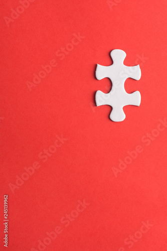 Unfinished white jigsaw puzzle pieces on red background