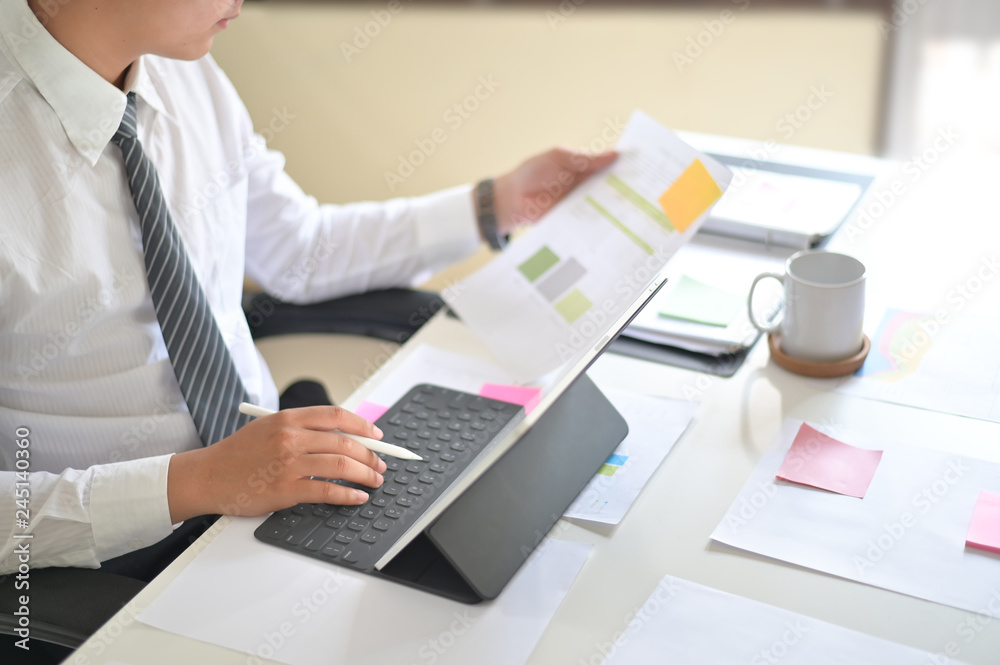 Businessman analyzing financial statistics displayed on the tablet screen. Businessman analyzing financial statistics displayed on the tablet screen.