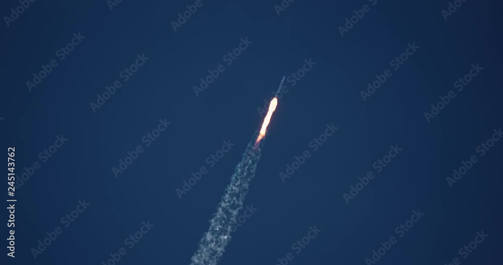 Nuclear missile flying through blue sky with exhaust flames and smoke in 4K.