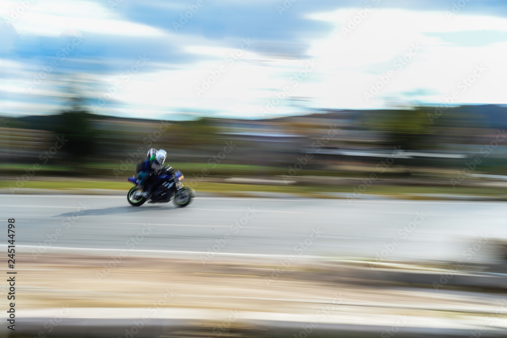 Motorbike passing with panning effect on the road