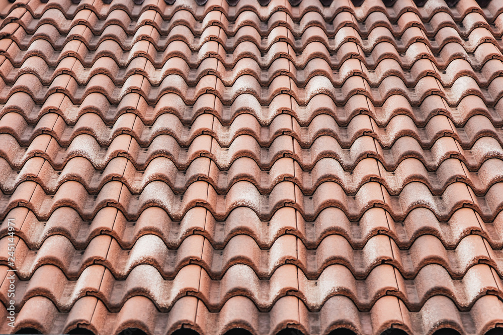 A horizontal texture of part of an old brown roof of clay tiles A horizontal texture of part of an old brown roof of clay tiles
